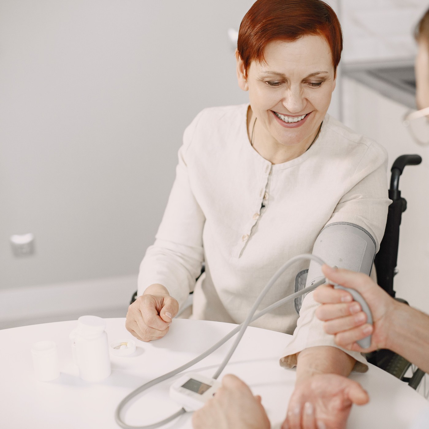 A smiling older woman having her blood pressure checked during a home health visit